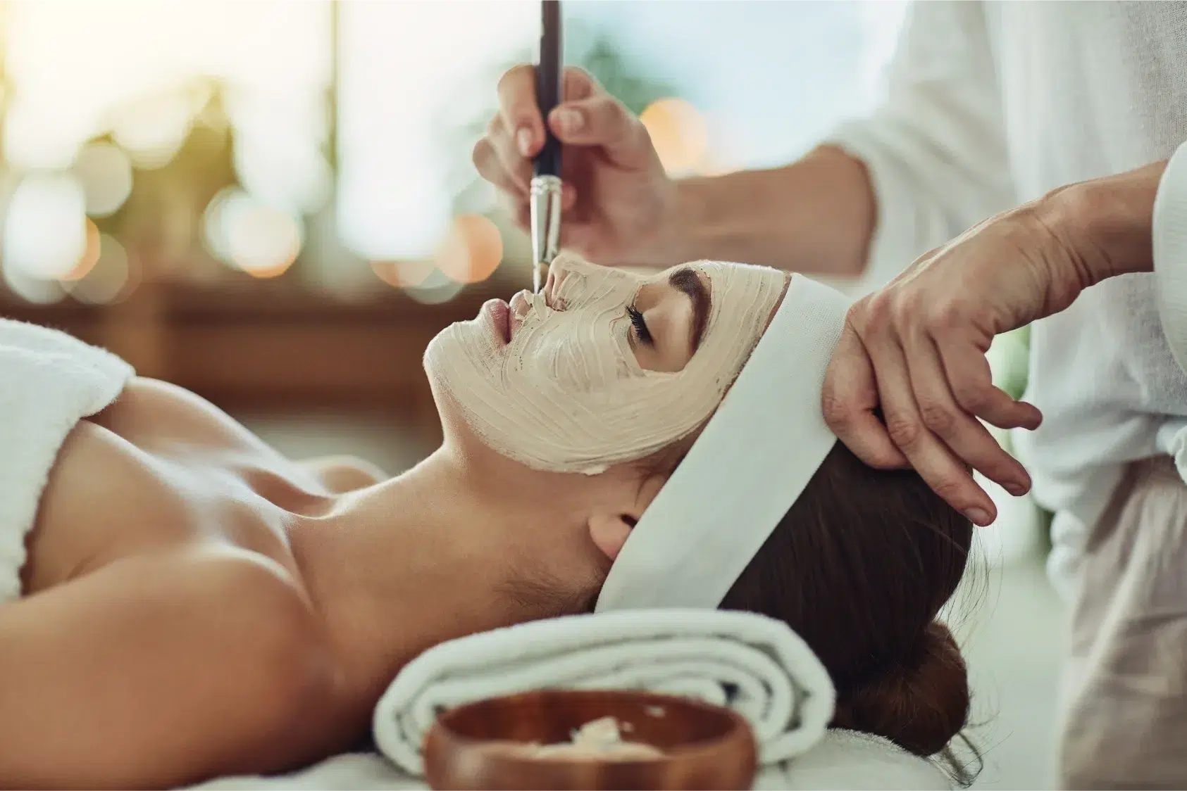 Woman getting a facial wrapped in towel