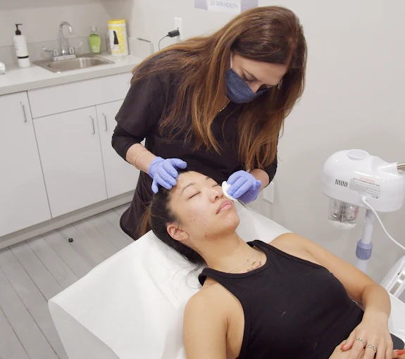 Certified Aesthetician working on clients face