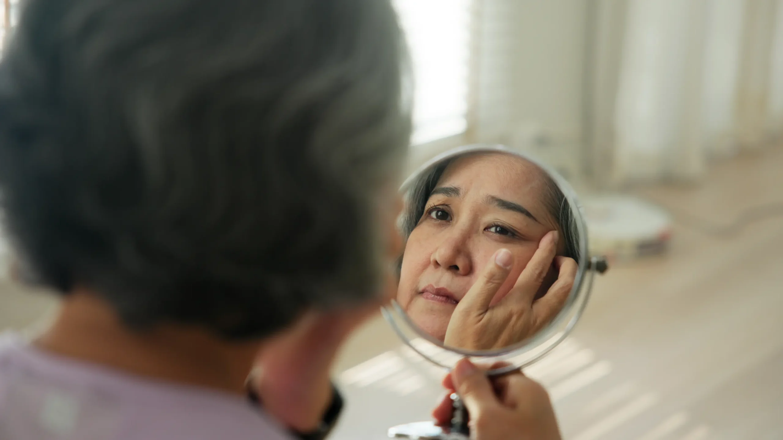 Woman looking concerned in mirror