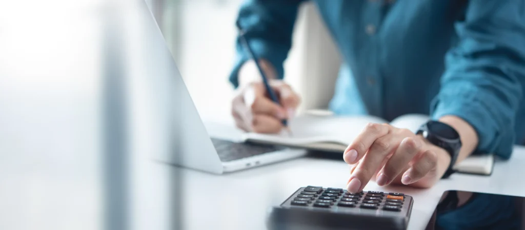 Person using a calculator to find out laser hair removal frachise cost